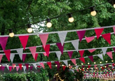 Festive streamers, in white, pink and red, handing from trees